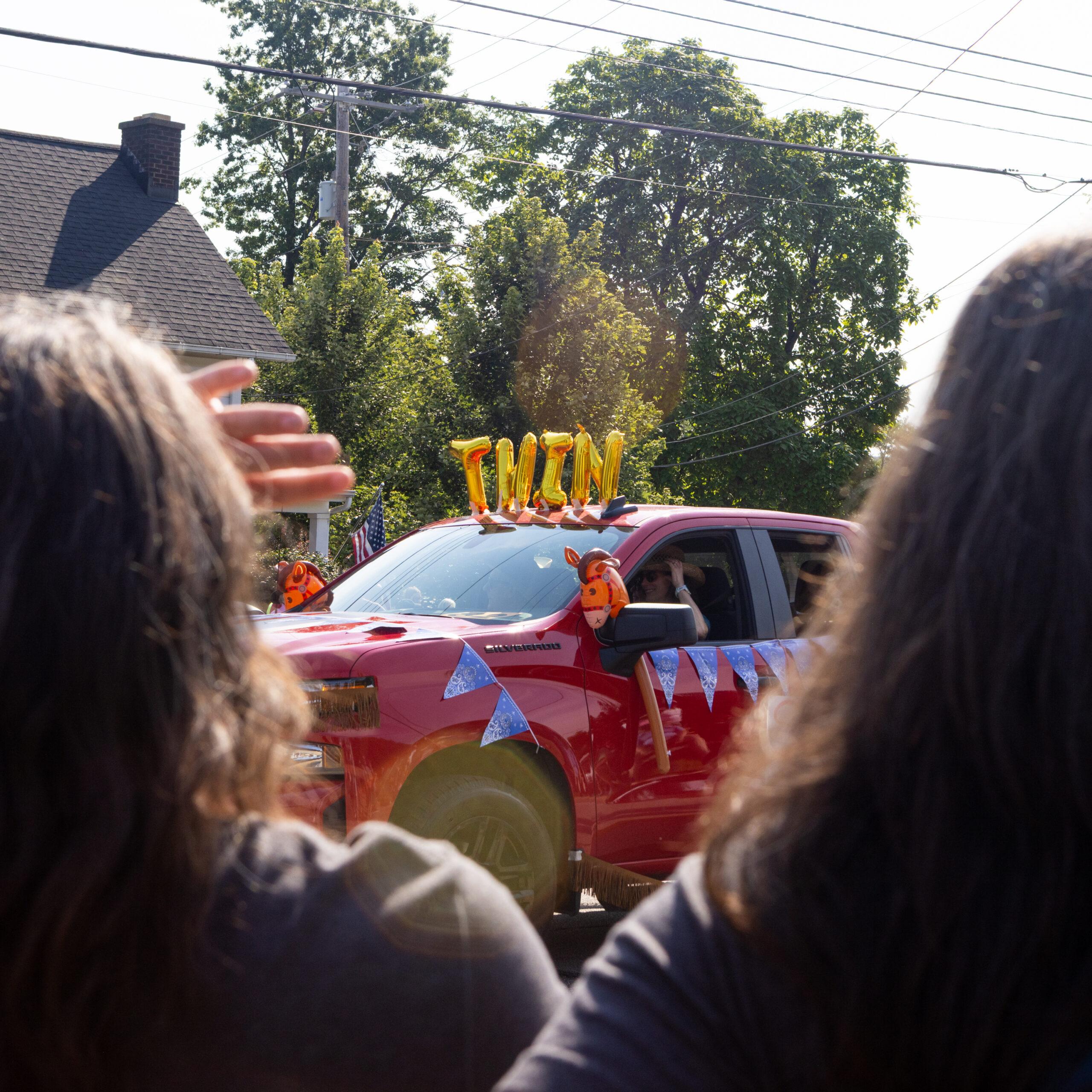 A truck with balloon letters spelling “TWINS” is seen in the Double Take parade at the Twins Days festival.