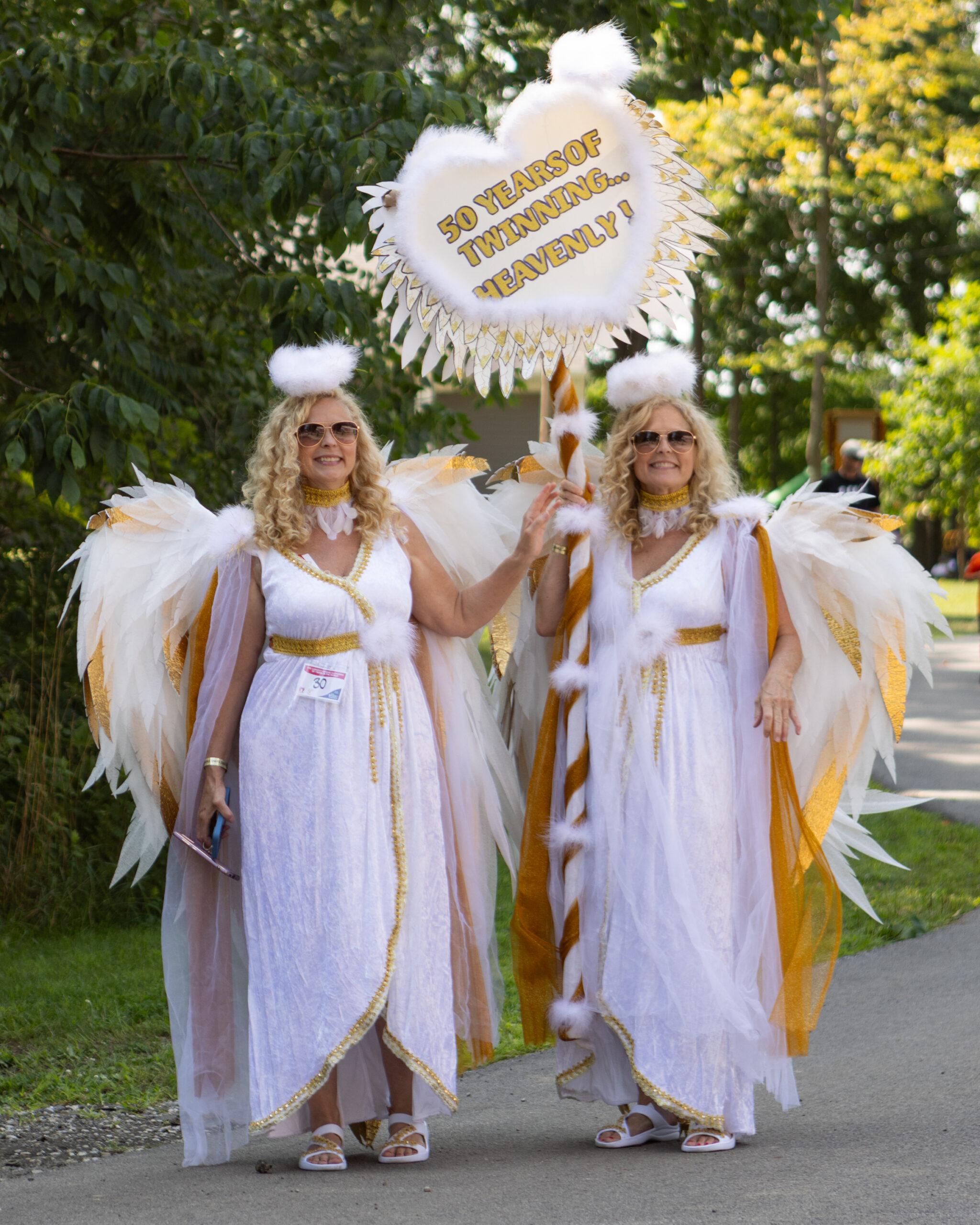 A set of blonde twins from Pittsburgh dressed as angels pose at the Twins Days festival.