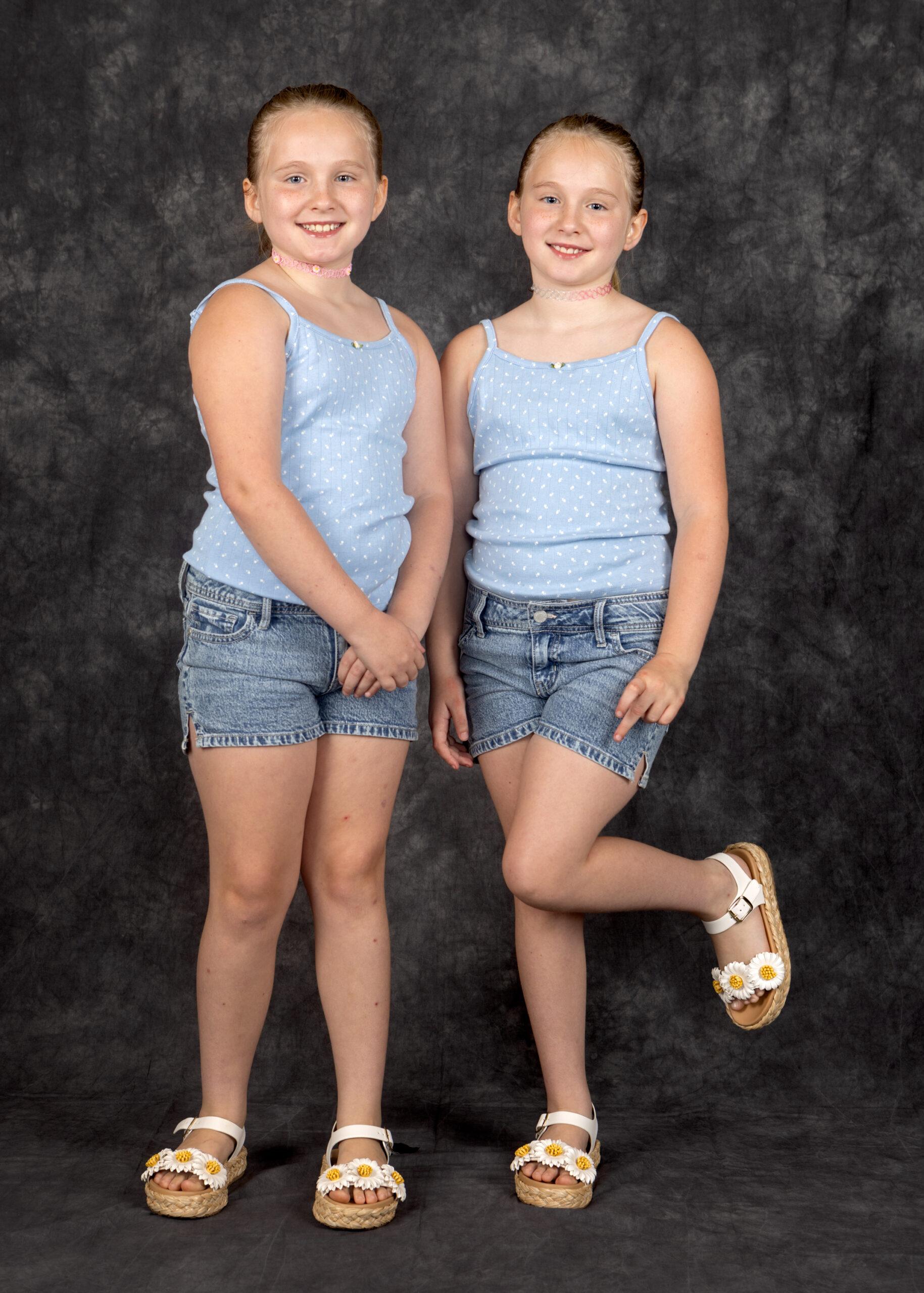 Twin sisters Aurora and Ariel Cheever smile for a portrait.